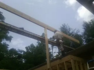 Carpenter setting a ridge beam over a new addition frame — Ice Dam Removal by Roofing Brothers in Franklin Furnace