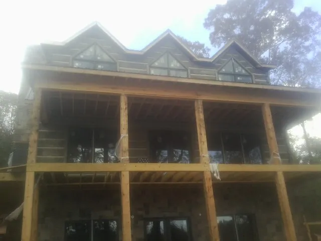 Dormers and porch framing on a large log home under construction — Roof Coating work by our crew in Franklin Furnace