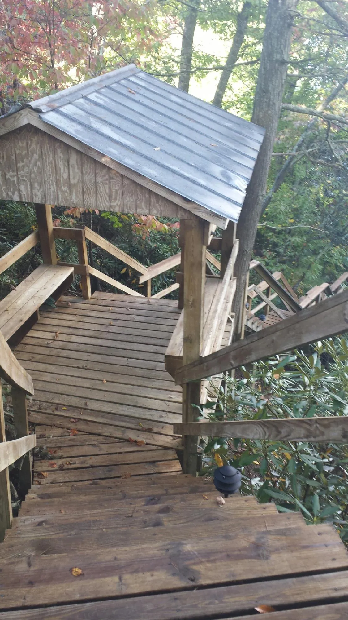 Metal roofed shelter over wooden steps on a wooded walkway — Skylight Repair & Installation work by our crew in Franklin Furnace