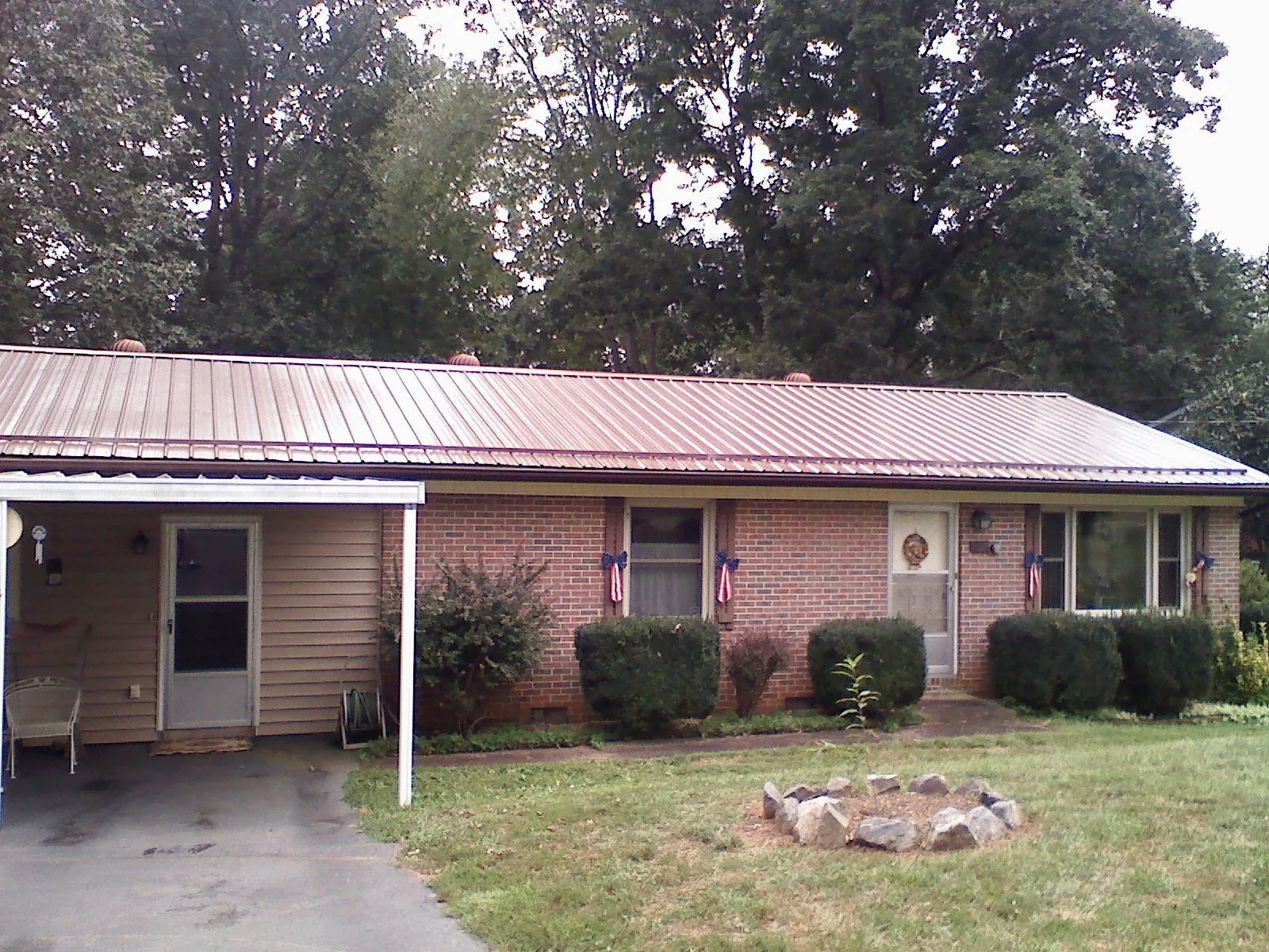 Bronze metal roof and carport on a brick ranch home — Roof Repair work by our crew in Franklin Furnace